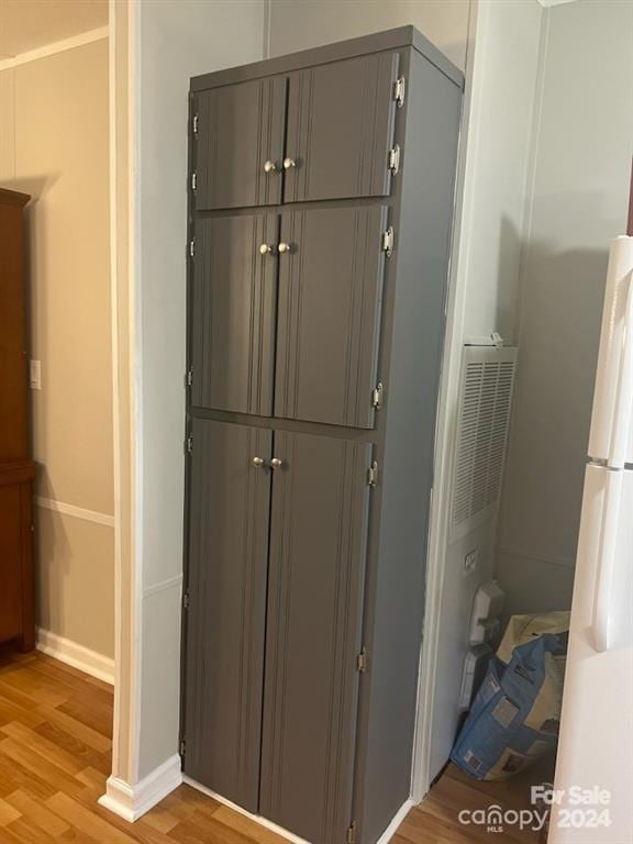 interior details featuring hardwood / wood-style flooring and white fridge