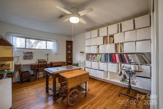 office with light hardwood / wood-style flooring and ceiling fan