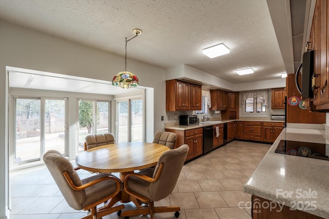 kitchen featuring pendant lighting, a textured ceiling, black appliances, sink, and light tile patterned floors