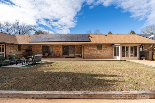 back of house featuring brick siding, a patio, and a lawn