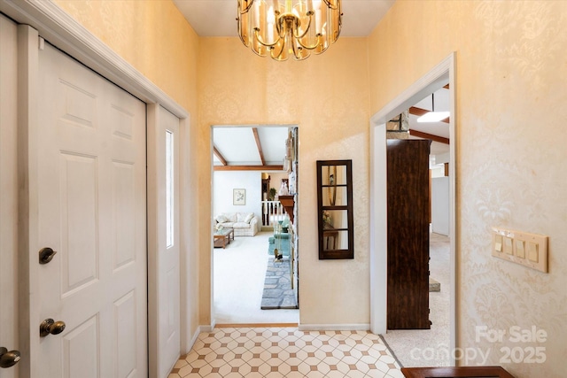 foyer entrance with baseboards and an inviting chandelier