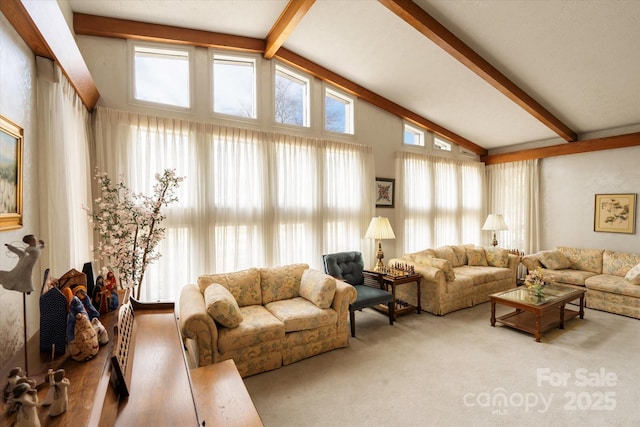 carpeted living area with high vaulted ceiling and beamed ceiling