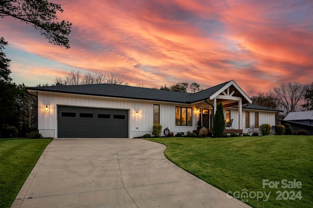 view of front of property with a yard and a garage