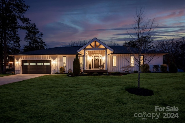 modern farmhouse with a garage and a lawn