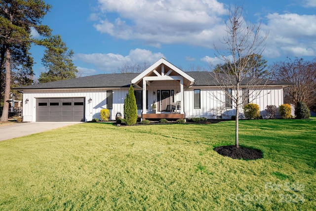 view of front of house featuring a front yard, a porch, and a garage