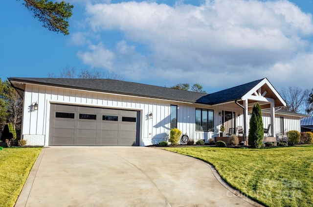 view of front of home featuring a front yard, a garage, and covered porch