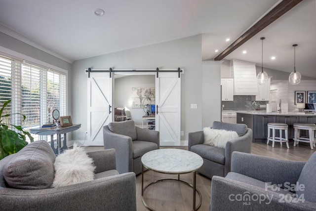 living room with a barn door and vaulted ceiling with beams