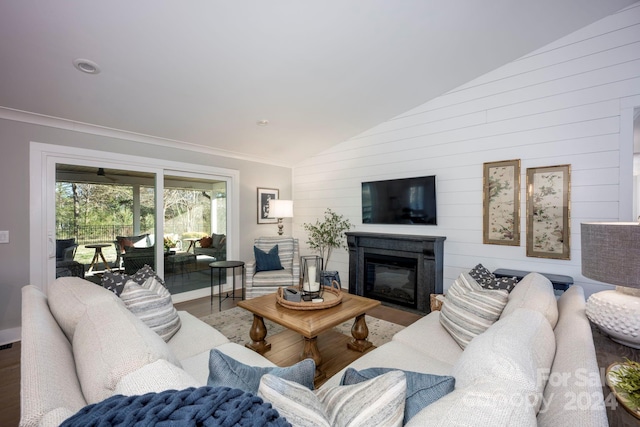 living room with wooden walls, hardwood / wood-style floors, crown molding, and lofted ceiling