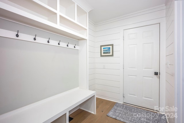 mudroom with hardwood / wood-style flooring and wooden walls