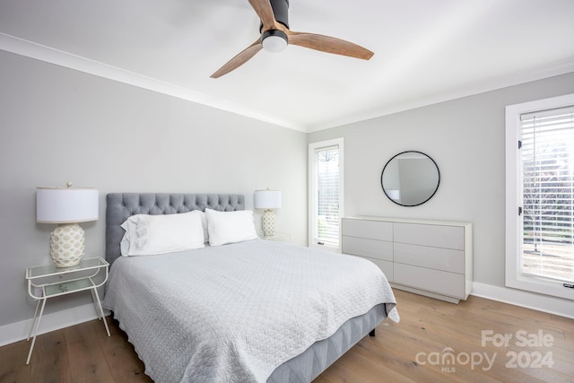 bedroom featuring multiple windows, ceiling fan, crown molding, and light hardwood / wood-style floors