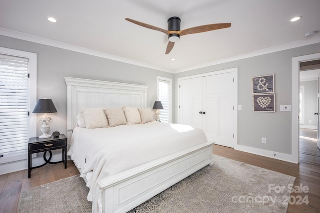 bedroom with dark hardwood / wood-style flooring, a closet, ceiling fan, and crown molding