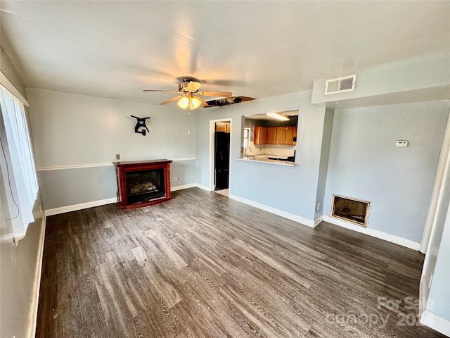 unfurnished living room featuring dark hardwood / wood-style floors and ceiling fan