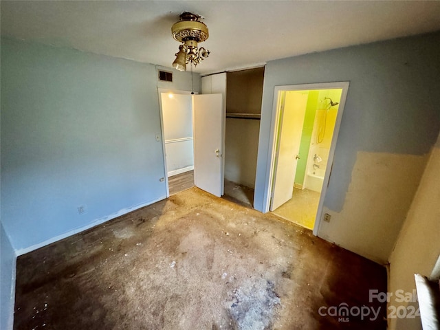 unfurnished bedroom featuring concrete flooring, connected bathroom, and a closet