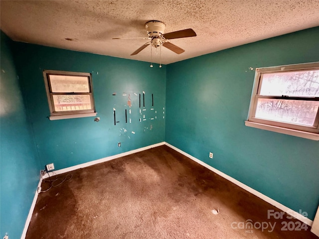 carpeted empty room with ceiling fan and a textured ceiling