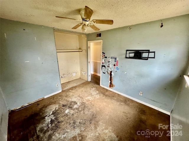 interior space featuring ceiling fan and a textured ceiling