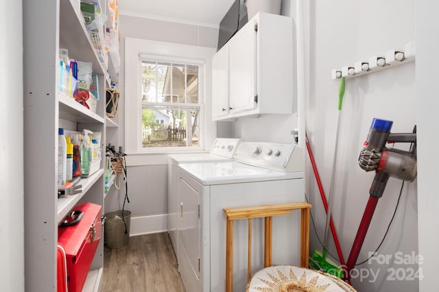 washroom with cabinets, washing machine and dryer, light hardwood / wood-style floors, and crown molding