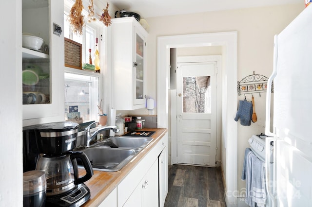 kitchen with white cabinetry, sink, dark hardwood / wood-style floors, and white refrigerator