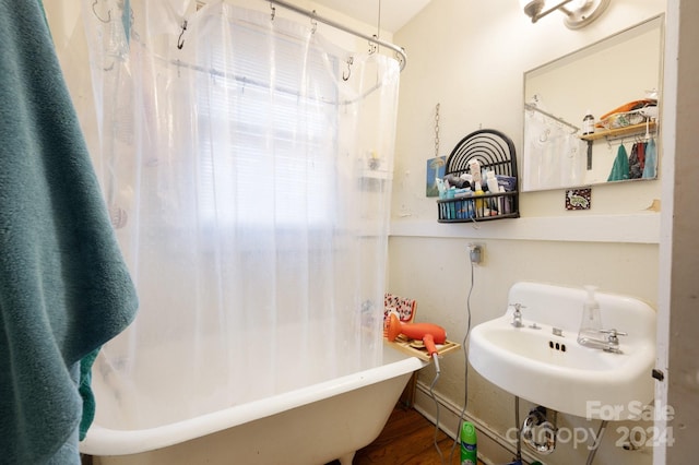 bathroom featuring hardwood / wood-style floors, shower / bath combination with curtain, and sink