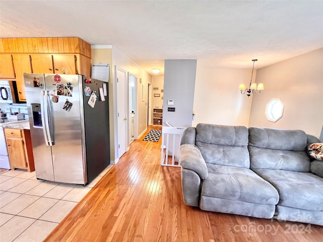 kitchen featuring light hardwood / wood-style flooring, an inviting chandelier, hanging light fixtures, and stainless steel appliances