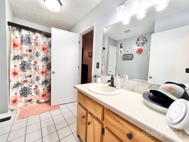 bathroom featuring tile patterned flooring, vanity, and a textured ceiling