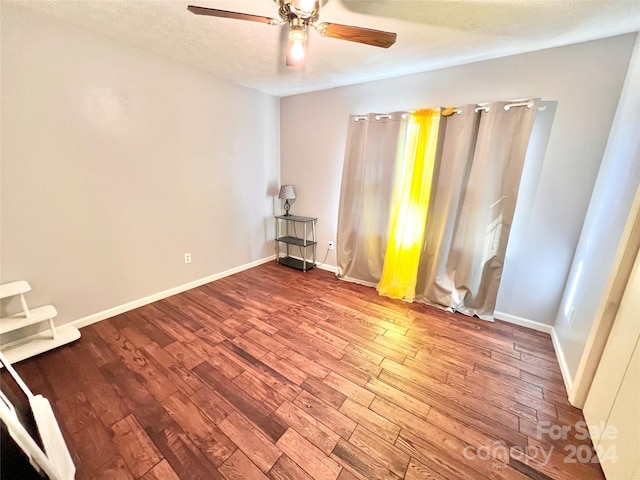 empty room featuring ceiling fan, a textured ceiling, and hardwood / wood-style flooring