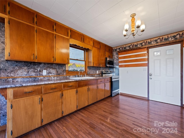 kitchen with appliances with stainless steel finishes, backsplash, dark wood-type flooring, and sink