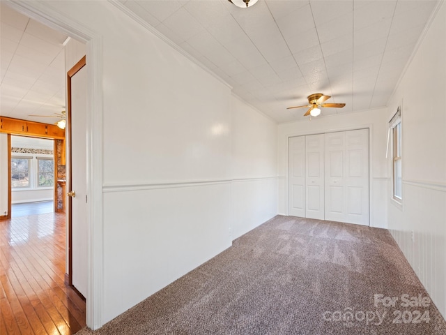 carpeted spare room featuring radiator, crown molding, and ceiling fan