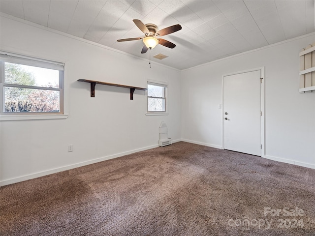 carpeted spare room with ceiling fan and ornamental molding