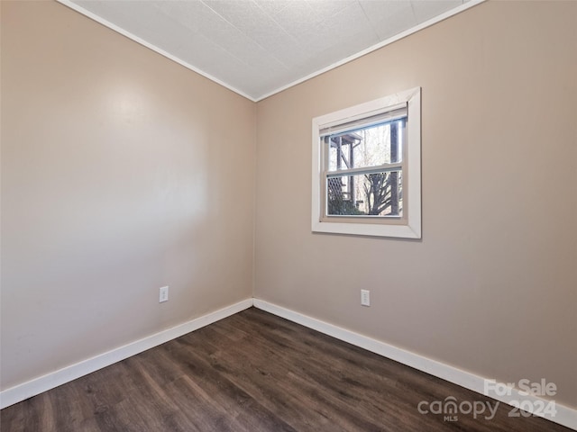 spare room with crown molding and dark hardwood / wood-style flooring