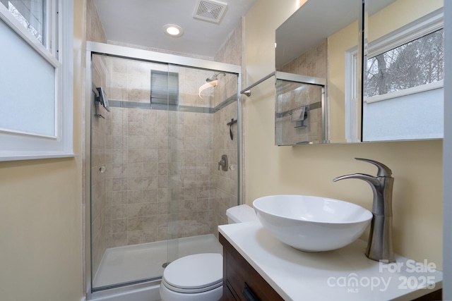 bathroom with vanity, an enclosed shower, and toilet