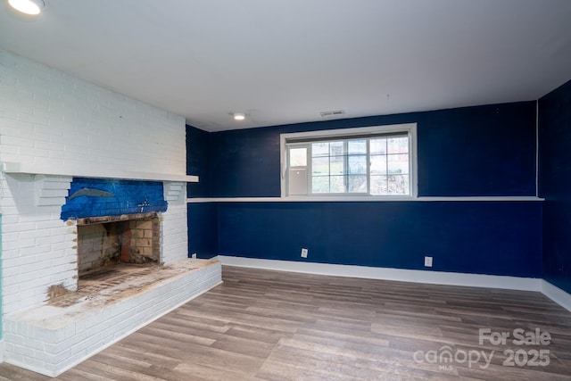 unfurnished living room with hardwood / wood-style floors and a fireplace