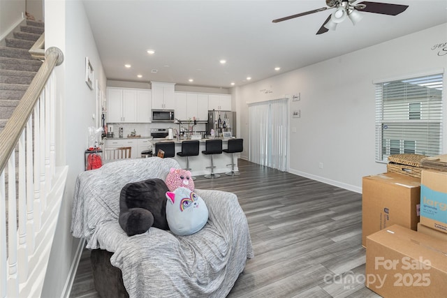 living room featuring ceiling fan and light hardwood / wood-style flooring