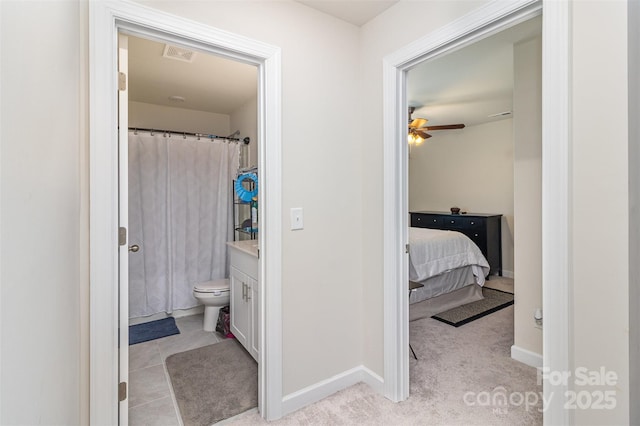 bathroom featuring curtained shower, ceiling fan, vanity, and toilet