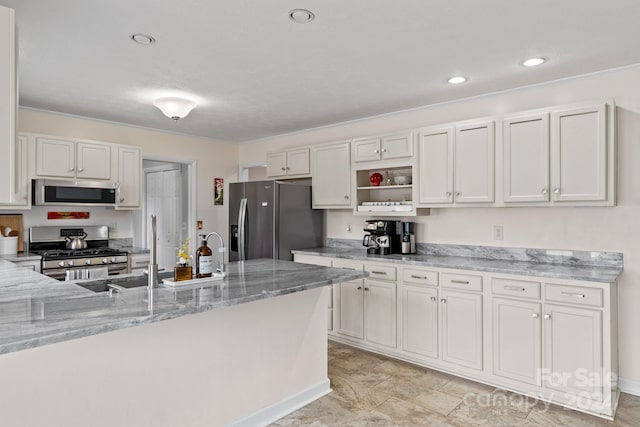 kitchen featuring white cabinets, stainless steel appliances, light stone countertops, and sink