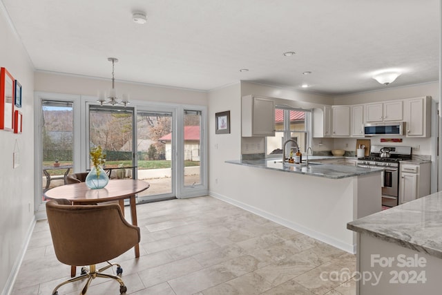 kitchen with sink, dark stone counters, pendant lighting, white cabinets, and appliances with stainless steel finishes