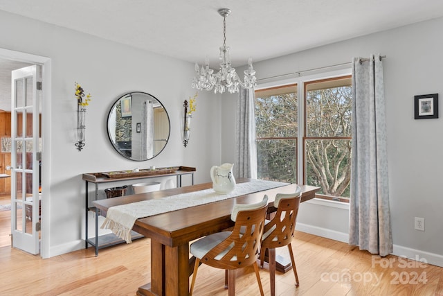 dining room featuring light wood-type flooring and an inviting chandelier