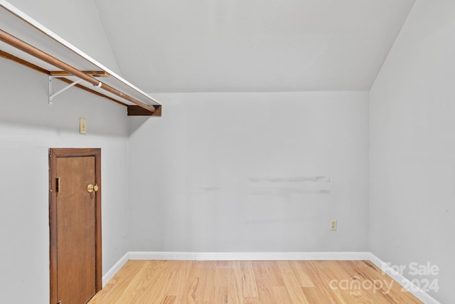 walk in closet featuring hardwood / wood-style floors and vaulted ceiling