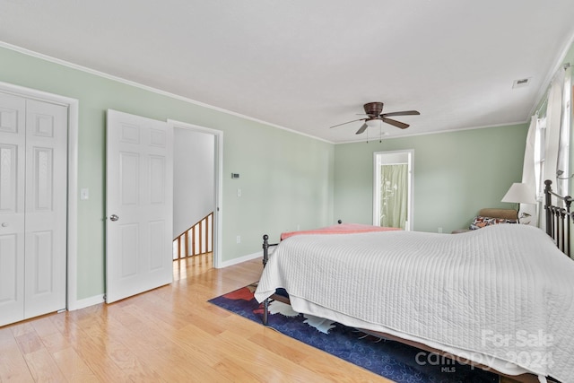 bedroom featuring ceiling fan, crown molding, and light hardwood / wood-style flooring