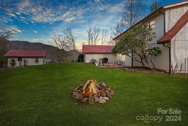 yard at dusk featuring a fire pit and a patio area