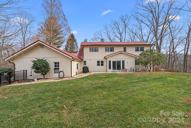 back of property with a yard and a patio