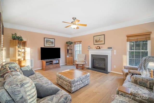 living room featuring ceiling fan, light wood-type flooring, and crown molding