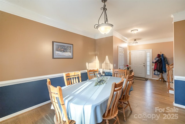 dining area featuring ornamental molding and hardwood / wood-style floors