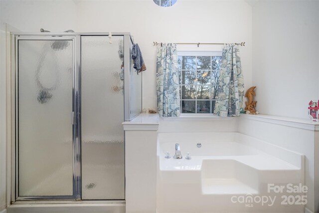 bathroom featuring shower with separate bathtub