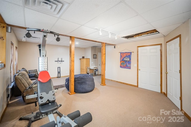 exercise room with a paneled ceiling and carpet