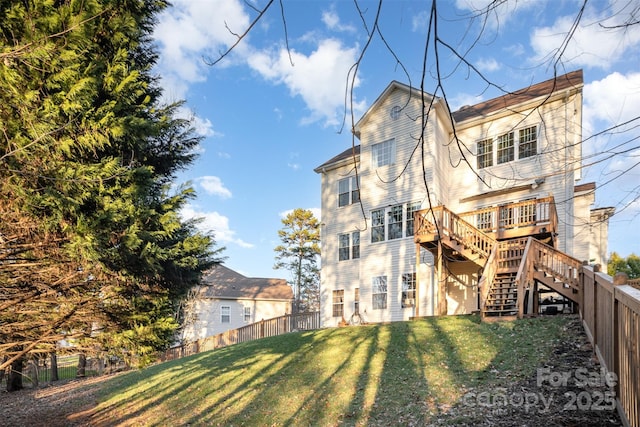 back of house featuring a deck and a lawn