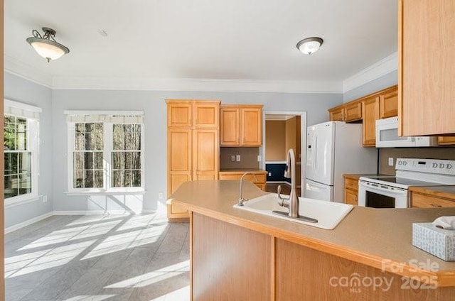 kitchen featuring white appliances, baseboards, a peninsula, crown molding, and a sink