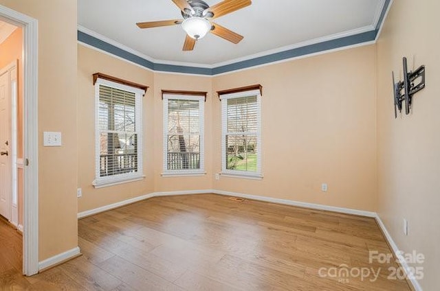 spare room featuring ornamental molding, a healthy amount of sunlight, and wood finished floors