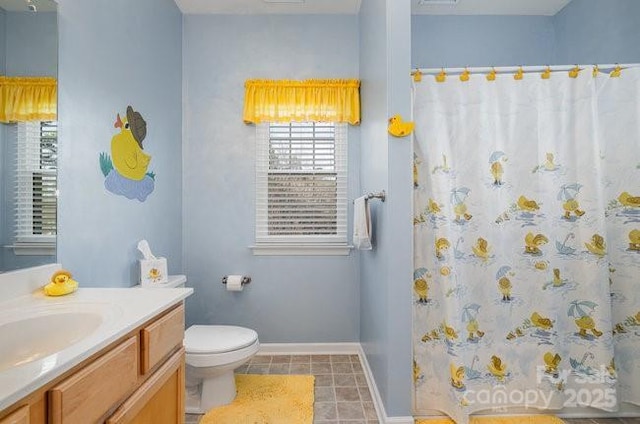 full bath with curtained shower, tile patterned flooring, toilet, vanity, and baseboards