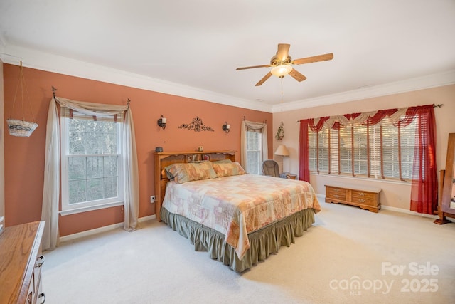 carpeted bedroom with ornamental molding, baseboards, and a ceiling fan