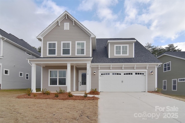 traditional-style home featuring an attached garage, a shingled roof, a front lawn, and concrete driveway